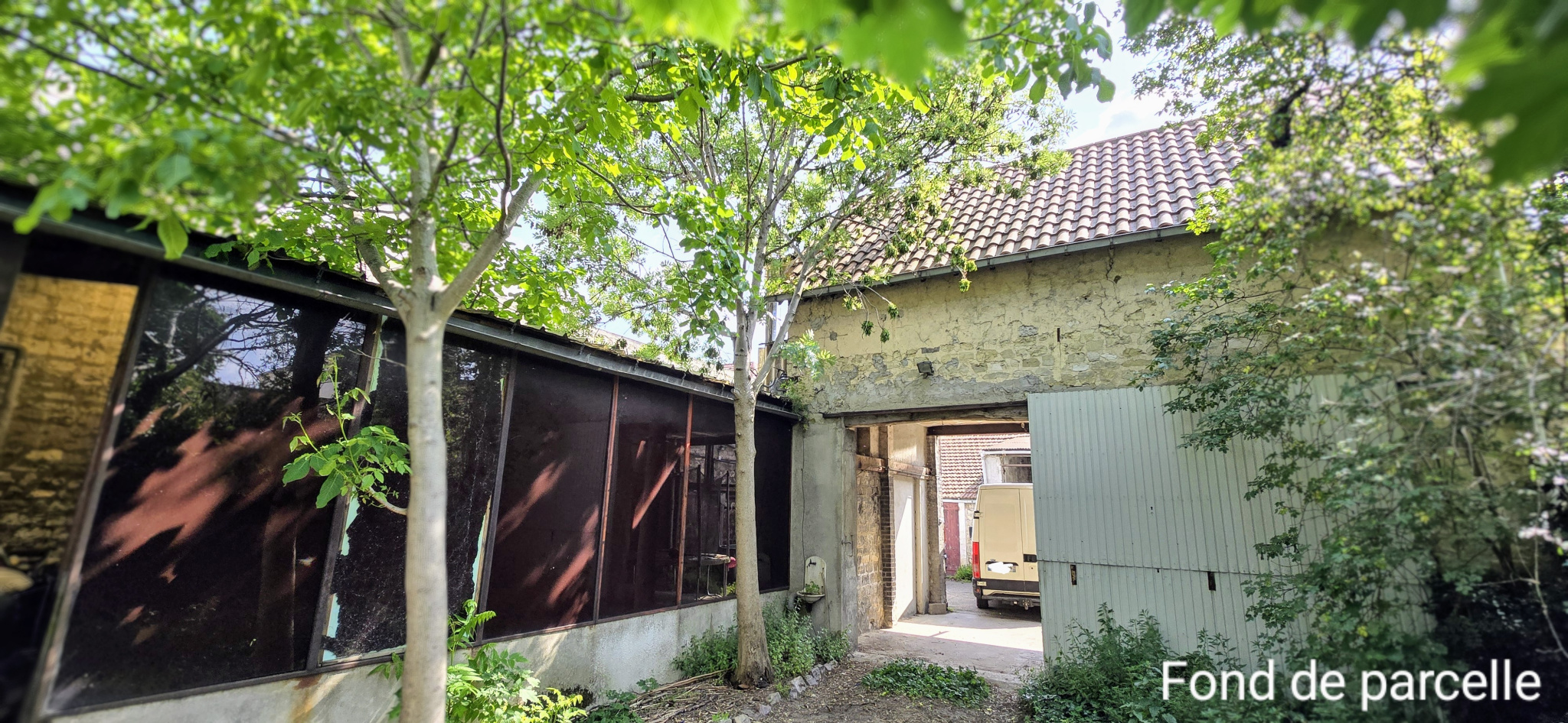 A  gauche une grand hangar sur jardin et à droite un studio.